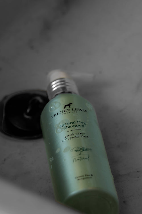 Dog shampoo bottle with visible brand name on a dark background