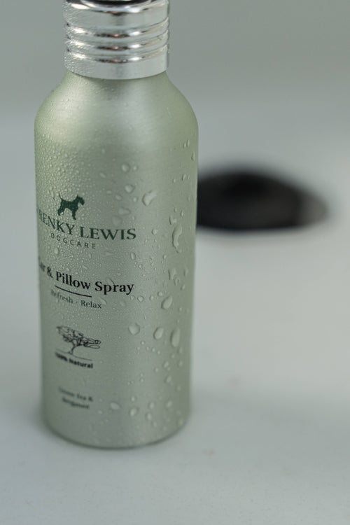 Green bottle of Henky Lewis pillow spray on a gray background