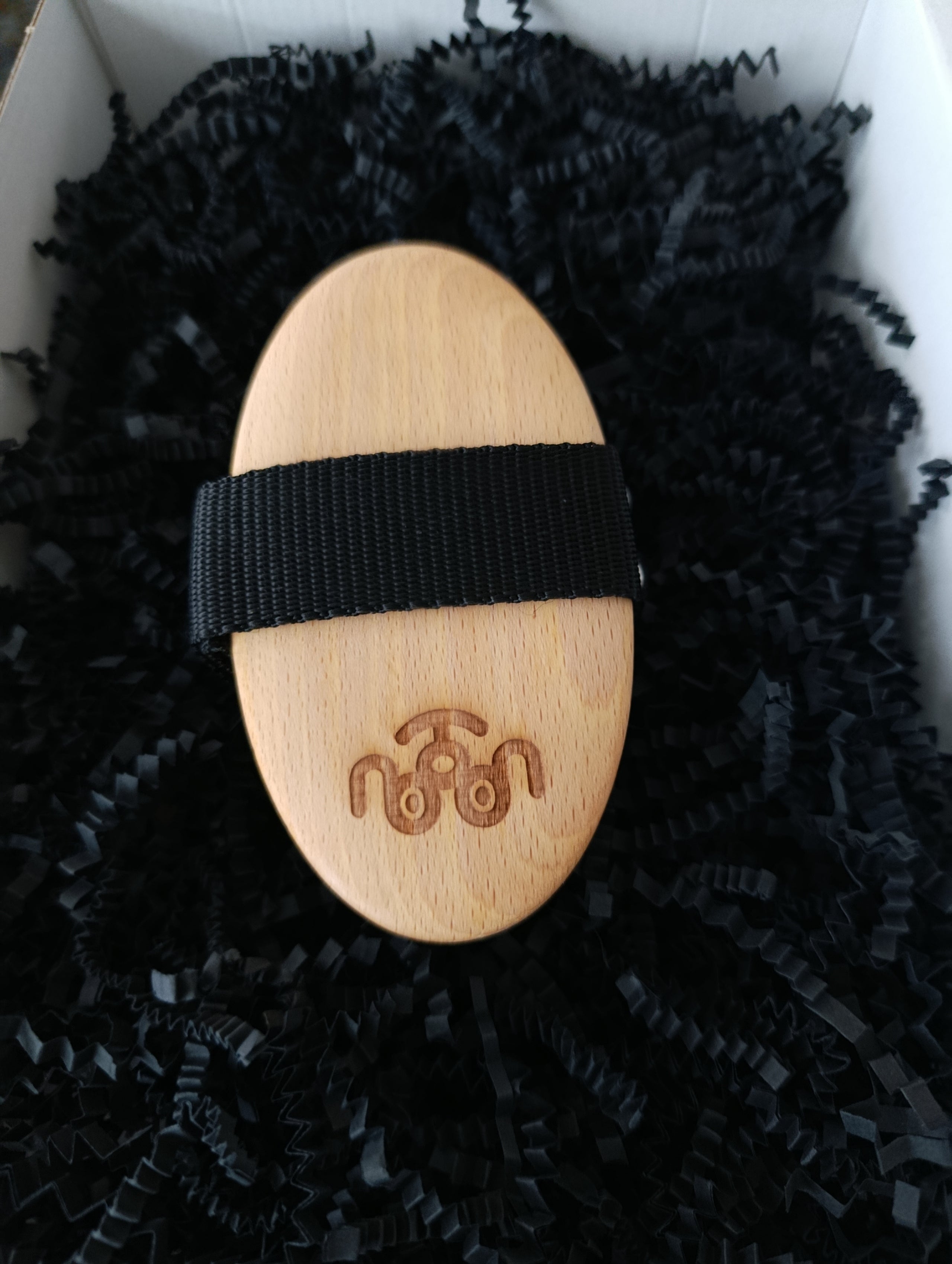 Wooden tool with black band on a black textured surface